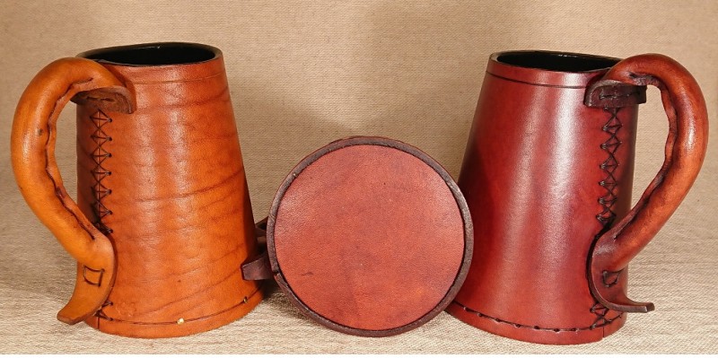 Leather tankards look intriguing and have been used since the medieval period.  A picture of two brown full grain leather tankards.